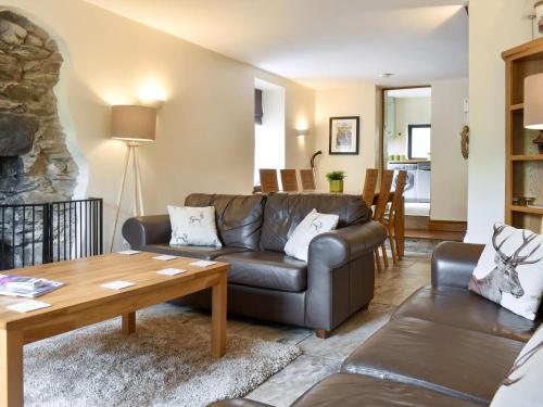 a living room with a couch and a table at Wood-Side Cottage in Backbarrow