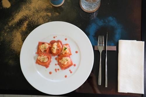 Un plato blanco con comida sobre una mesa. en Warmthotel, en Roma