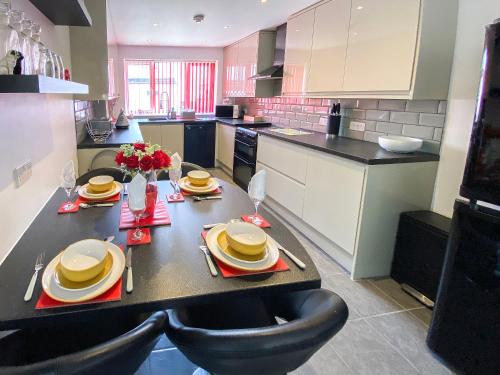 a kitchen with a table with chairs and a tableasteryasteryasteryasteryasteryastery at Thistle Dew in Great Yarmouth