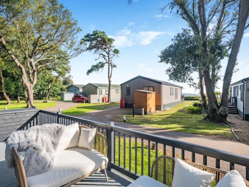 een bank op een terras met uitzicht op huizen bij Tranquil Dawn in Corton