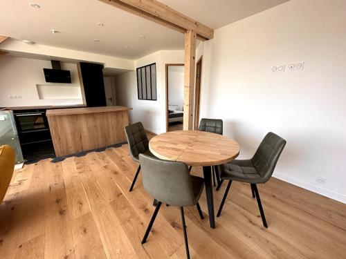 une salle à manger avec une table et des chaises en bois dans l'établissement Beautiful new T3 Duplex sea view, à Étel