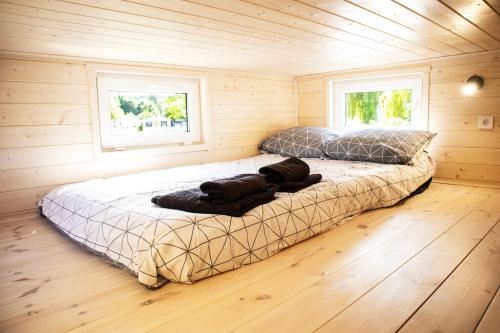 a bedroom with two beds in a wooden cabin at 3 WIDOKI Kiekrz -domki Tiny House z prywatną plażą i pomostem nad jeziorem Kierskim in Poznań