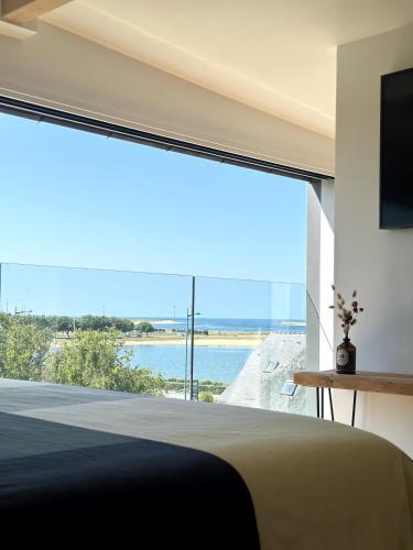 - une chambre avec une grande fenêtre donnant sur l'océan dans l'établissement Beautiful new T3 Duplex sea view, à Étel