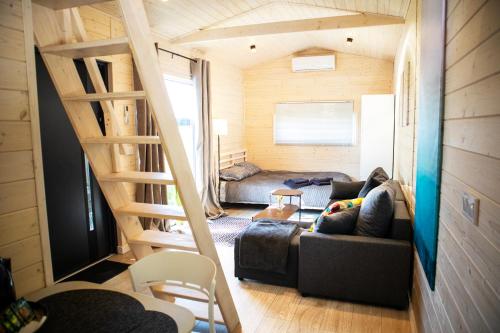a living room with a couch and a staircase at 3 WIDOKI Kiekrz -domki Tiny House z prywatną plażą i pomostem nad jeziorem Kierskim in Poznań