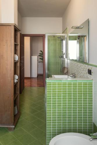 a bathroom with a tub and a sink and a mirror at Casa Fiore by Vayadù in Savigliano