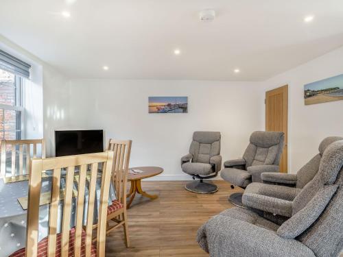 a living room with a couch and chairs and a table at Two Little Ducks in Wells next the Sea