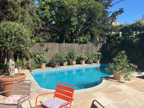 - une piscine avec 2 chaises longues et des plantes dans l'établissement Saint-Jean-des-Cèdres, à Aix-en-Provence