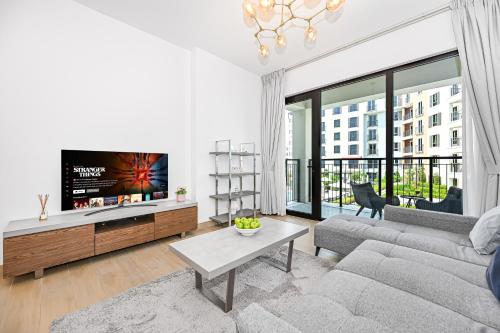 a living room with a couch and a flat screen tv at Majestic Port de La mer sea view 2BR in Dubai