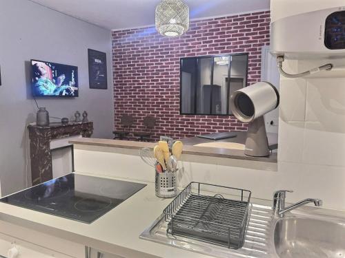 une cuisine avec un évier et une cuisinière four supérieur dans l'établissement Appartement lumineux aux portes de Paris Séjour longue durée idéal Pour Couple & Professionnels, à Malakoff