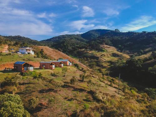 a house on top of a hill with houses on it at Pousada Ho'oponopono Chalets & Wine in Sapucaí-Mirim