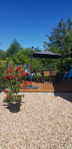 a wooden deck with a picnic table and an umbrella at les bouchos in Yves