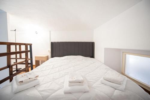 a bedroom with a large white bed with towels on it at Modern and serviced apartment in Turin