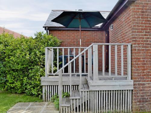 un escalier avec un parapluie attaché à une maison dans l'établissement Woods Cottage, à Evershot
