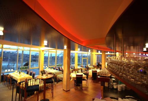 فندق - ستاوسي في ميتزينغين: غرفة طعام مع طاولات وكراسي ونوافذ