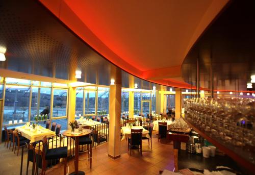 a dining room with tables and chairs and windows at Stausee-Hotel in Metzingen