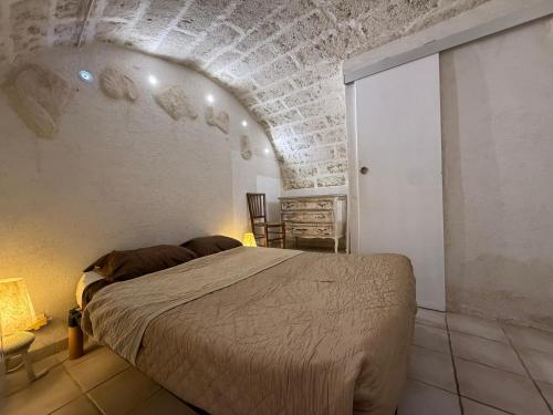 une chambre avec un lit et un mur de briques dans l'établissement Appartement P2 à 4km D'UZÈS, à Saint-Quentin-la-Poterie