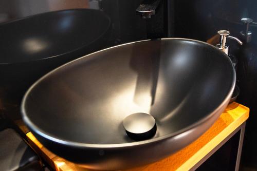 a black bath tub sitting on top of a sink at 3 WIDOKI Kiekrz -domki Tiny House z prywatną plażą i pomostem nad jeziorem Kierskim in Poznań