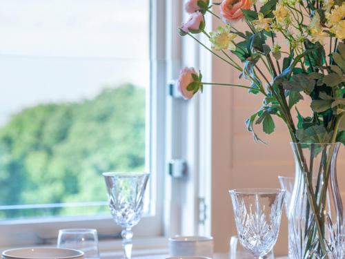 a table with glasses and a vase with flowers at Haven Heights in Martinhoe