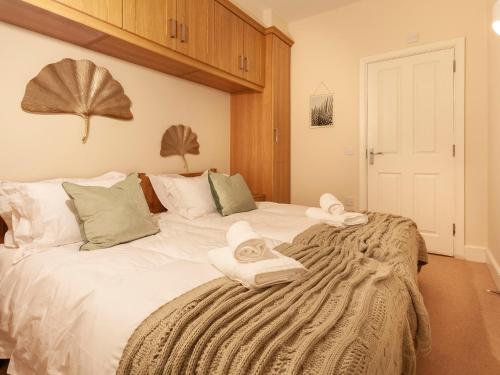 a bedroom with a large white bed with towels on it at Haven Heights in Martinhoe