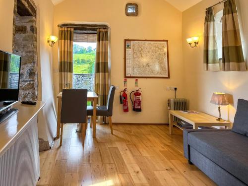 a living room with a couch and a table at Ravenscliffe Cottage in Tissington