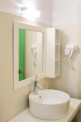 a bathroom with a white sink and a mirror at Anemos Guest Apts in Karpathos