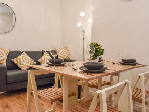 a dining room with a table and a couch at Jet Workers Cottage in Whitby