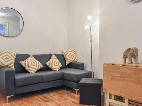 a living room with a couch and a mirror at Jet Workers Cottage in Whitby