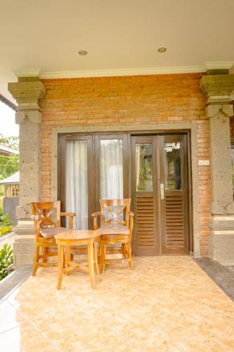 a patio with a table and chairs and a building at Mesari Cottage Guest House in Buleleng