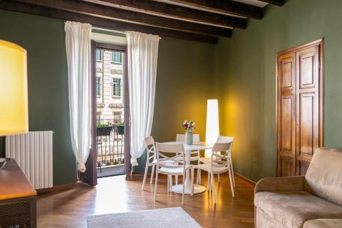 a living room with a table and chairs and a couch at LP Apartments - Navigli View in Milan