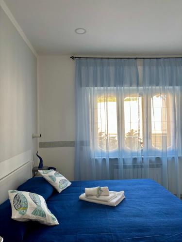 a bedroom with a blue bed with towels on it at Riflesso D'Azzurro in Meta