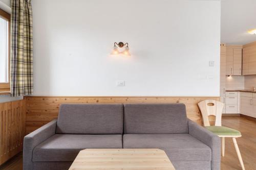 a living room with a couch and a table at Residence Nussbaumer in Siusi