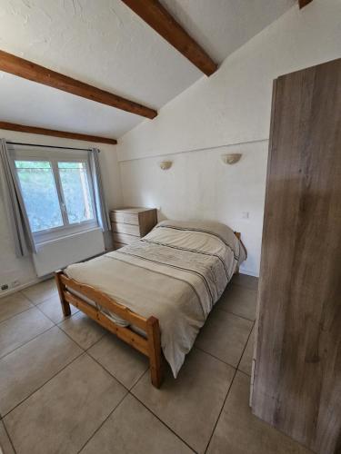 une chambre avec un lit dans une pièce avec une fenêtre dans l'établissement Les Roses, à Bézaudun-les-Alpes