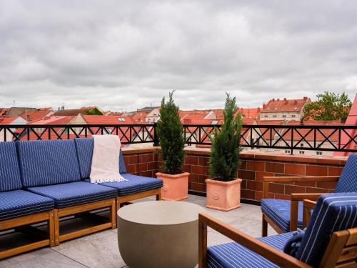 a balcony with blue chairs and a table and buildings at Hotel Reja, a Member of Design Hotels in Klaipėda