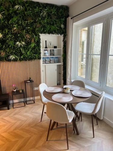une table et des chaises dans une pièce dotée d'un mur vert dans l'établissement Appartement au pied des remparts, à Boulogne-sur-Mer