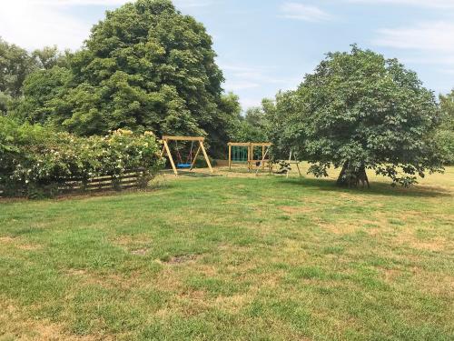 a park with a swing set and a tree at Kestral in Welney