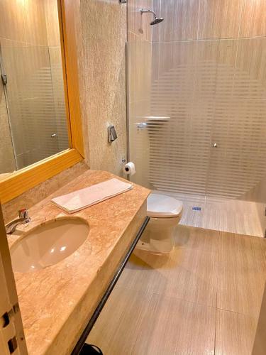 a bathroom with a sink and a toilet and a shower at Pousada e Motel Blue Inn in Cascavel