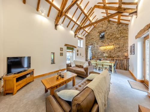 a living room with a couch and a tv at Ty Carreg in Llanbadarn-fawr
