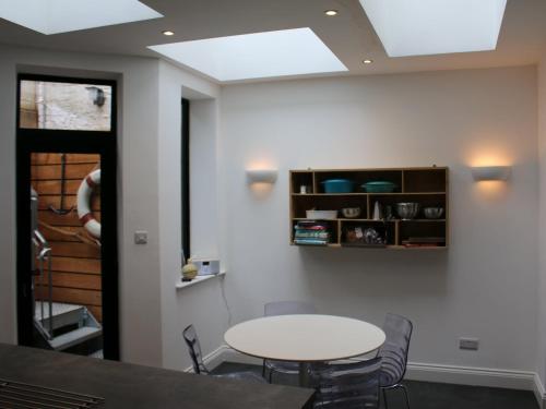a table and chairs in a room with a ceiling at Bay House in Hastings