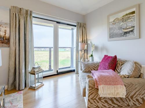 ein Wohnzimmer mit Couch und großem Fenster in der Unterkunft Kittiwake in Amble