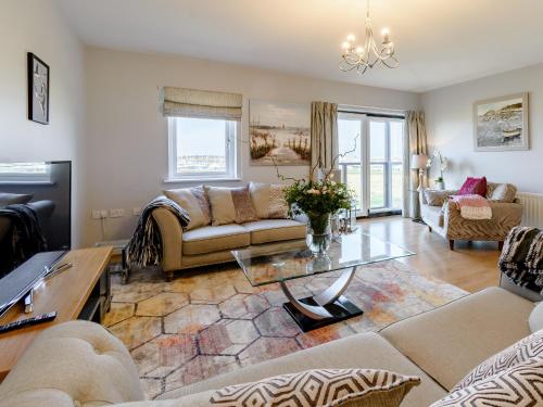 ein Wohnzimmer mit Sofa und Tisch in der Unterkunft Kittiwake in Amble