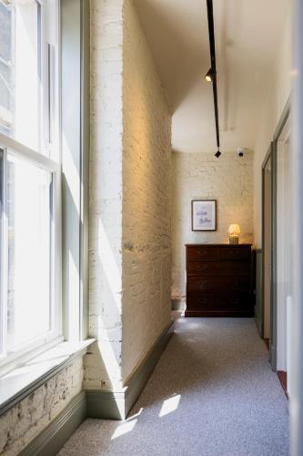 an empty hallway with a large window and a dresser at The London & Paris Hotel in Folkestone