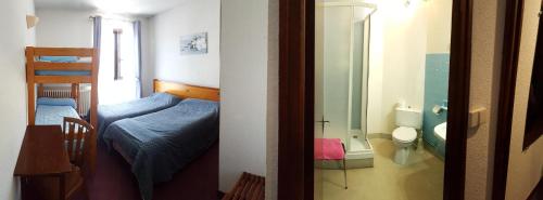 Cette chambre comprend deux lits et une salle de bains pourvue de toilettes. dans l'établissement Hotel La Grange, à Boutx