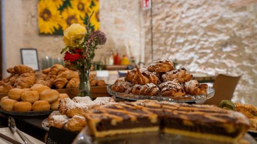 a table topped with trays of pastries and other desserts at Villa Balis Crema Verona Hills in Grezzana