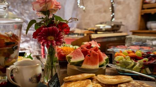 a table with a bunch of fruit and a vase with flowers at Villa Balis Crema Verona Hills in Grezzana