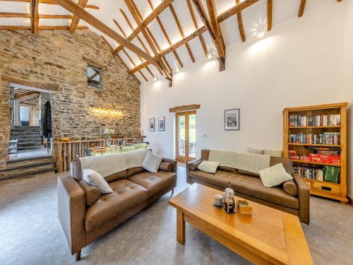 a living room with two couches and a table at Ty Carreg in Llanbadarn-fawr