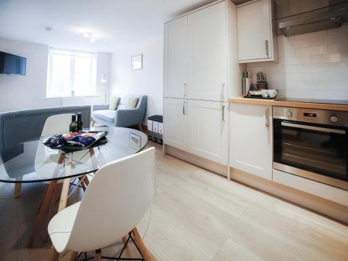 a kitchen with a glass table and white cabinets at Borrowdale View - Uk45176 in Threlkeld