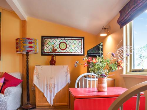 a living room with a table and a window at Owls Nest in Stradbroke