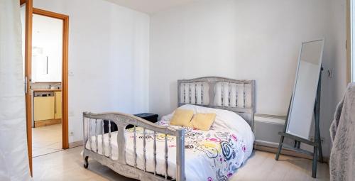 une chambre avec un lit et un miroir dans l'établissement Appartement lumineux Abbé, à Marseille