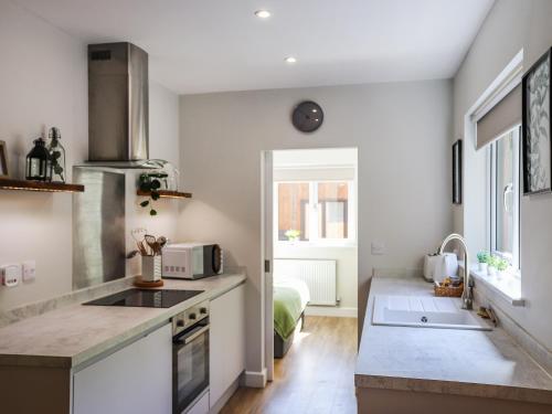 a kitchen with a sink and a stove at Peris Lodge - Uk47606 in Caernarfon