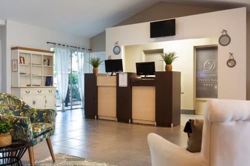a lobby with a reception desk with two computers on it at SOWELL HOTELS Domaine de la Petite Isle in LʼIsle-sur-la-Sorgue